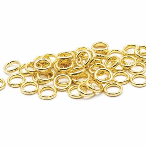 Op de afbeelding: Een stapel gouden springringen, een soort sieraadbevestiging die wordt gebruikt om kettingen, koorden en andere sieradencomponenten te verbinden.