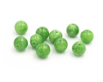Op de afbeelding: Een groep van tien ronde groene jade kralen met een gat door het midden van elke kraal.