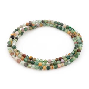 May include: A multi-coloured gemstone beaded bracelet with green, brown, and yellow beads.