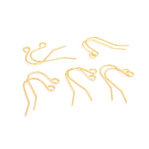 Op de afbeelding: Een set van zes gouden oorhaken. De haken zijn gemaakt van metaal en hebben een eenvoudig, elegant ontwerp.