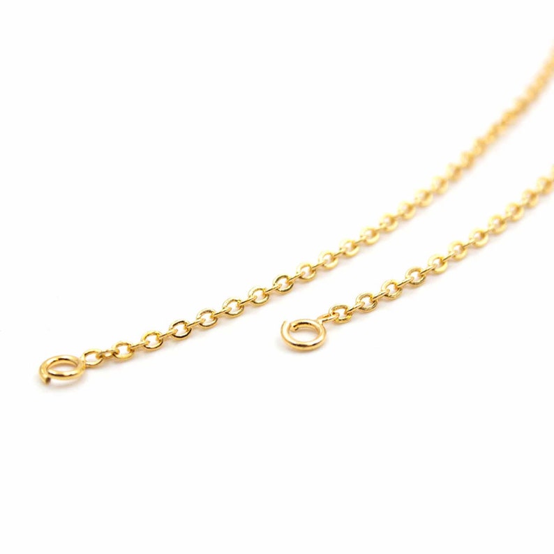 May include: A gold chain necklace with two jump rings at the ends.