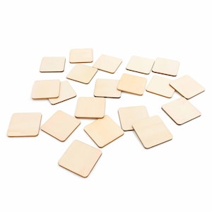 Könnte beinhalten: Eine Sammlung kleiner, quadratischer Holzfliesen. Die Fliesen haben eine helle, natürliche Holzfarbe und sind auf einem weißen Hintergrund verstreut. Die Kanten der Fliesen sind leicht abgerundet.