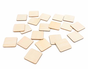 May include: A collection of small, square wooden tiles. The tiles are a light, natural wood color and are scattered across a white background. The edges of the tiles are slightly rounded.