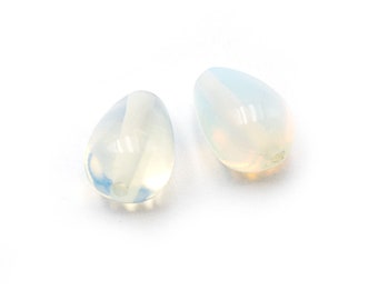 May include: Two teardrop-shaped opal beads, one with a slight yellow hue and the other with a slight blue hue.