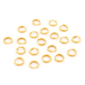 Könnte beinhalten: Eine Sammlung von 18 goldenen Sprungringen, ideal für die Schmuckherstellung oder Bastelprojekte.