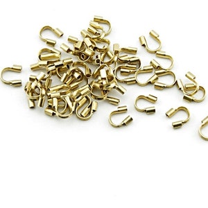 Peut inclure: Un tas de perles à sertir en métal doré, utilisées pour la fabrication de bijoux.