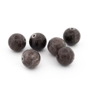 May include: Six round, dark grey beads with a smooth, polished finish.