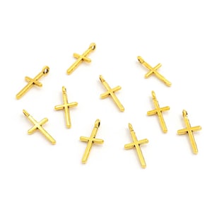 May include: Ten gold-toned metal cross charms with a loop for attaching to jewellery or other crafts.