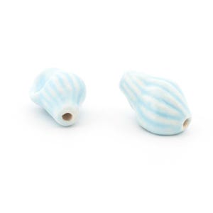May include: Two light blue ceramic beads with white striped patterns. The beads have a rounded shape with a hole for stringing. The beads are on a white background. These beads are suitable for jewelry making.