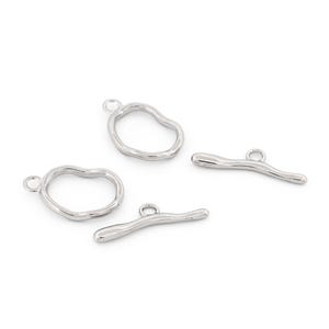 May include: Four silver-coloured metal jewellery charms. Two are irregular circles, and two are curved bars, all with small loops for attaching to jewellery. The charms are on a white background.