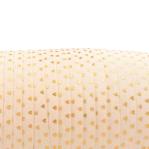 May include: A roll of cream-colored ribbon with a repeating pattern of small gold hearts. The ribbon is tightly wound, and the hearts are evenly spaced across the surface. The ribbon is likely used for crafting or gift wrapping.