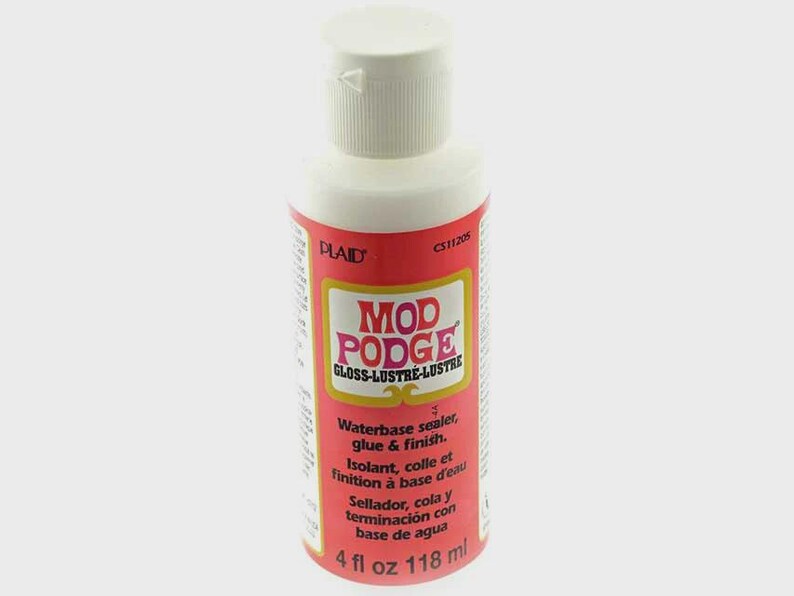 以下が含まれることがあります： 水性シーラー、接着剤、仕上げ剤のMod Podge Gloss Lustre 118mlボトル。ボトルは白で、赤いラベルには白い文字で「Mod Podge Gloss Lustre」と書いてあります。ラベルには、英語、フランス語、スペイン語の指示も記載されています。