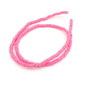 May include: A strand of pink polymer clay beads, each bead is a flat circle with a hole in the centre.