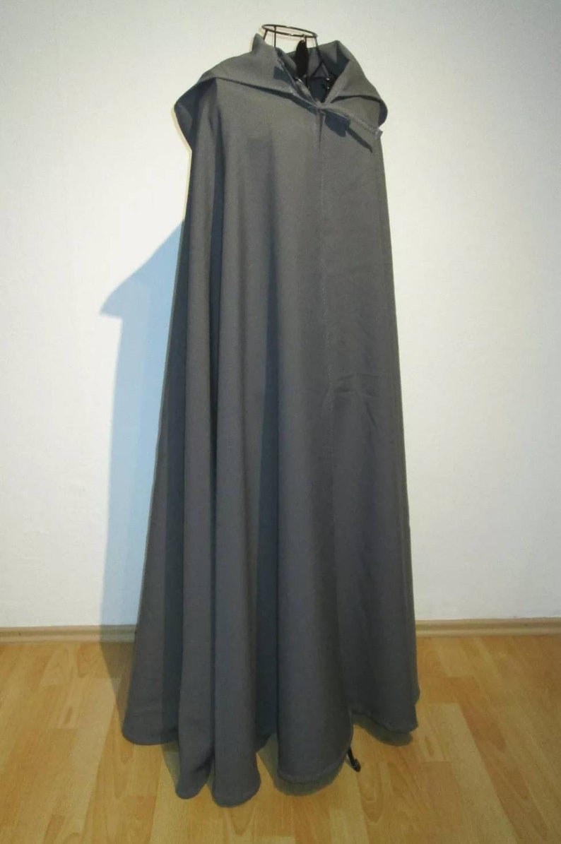May include: A long, gray hooded cloak with a simple design. The cloak is made of a soft, flowing fabric and has a drawstring closure at the neck.