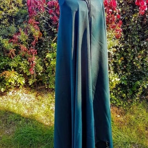 May include: A dark green hooded cloak with a zipper closure. The cloak is made of a soft, flowing fabric and is perfect for adding a touch of mystery and intrigue to any costume.