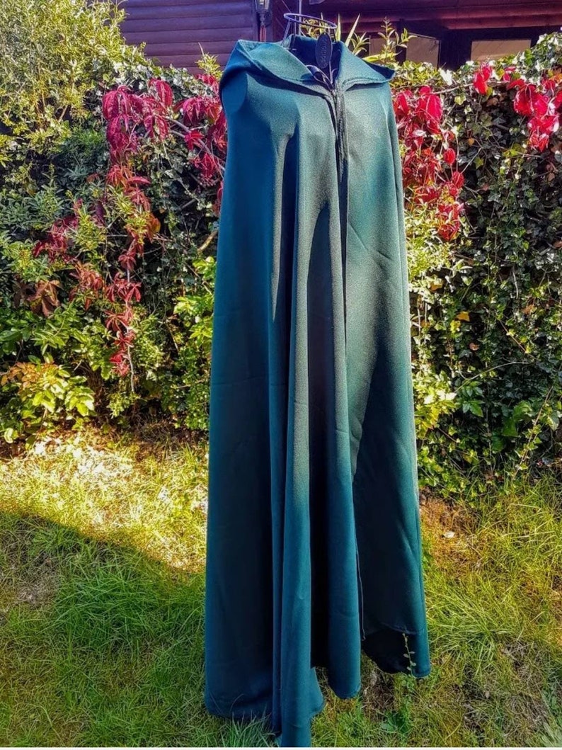 May include: A dark green hooded cloak with a zipper closure. The cloak is made of a soft, flowing fabric and is perfect for adding a touch of mystery and intrigue to any costume.