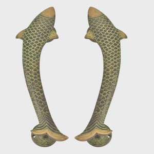 May include: Pair of bronze-colored door handles shaped like fish. The handles have a curved design with a scaled body and a fish head at the top. The handles are approximately 10 inches long.