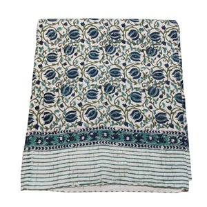 May include: A folded white textile featuring a repeating pattern of blue floral designs and green vines. The border has a striped pattern in shades of green and white. This textile is likely a tablecloth or home decor item.