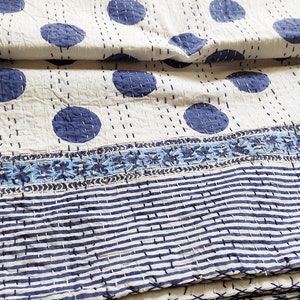 Può includere: Trapunta kantha bianca con un motivo a pois blu e un bordo a righe blu e bianco. La trapunta è piegata in tre.