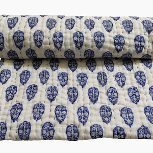 May include: White cotton quilt with a blue floral pattern. The quilt is hand-stitched and has a traditional Indian design.
