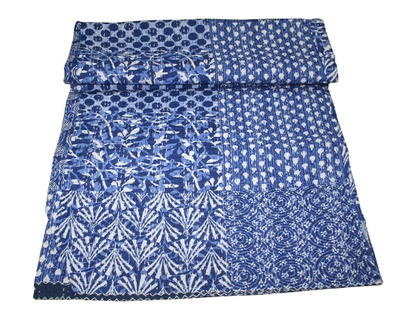 May include: A blue and white kantha quilt with a patchwork design. The quilt is made of cotton and has a hand-stitched look.