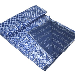 May include: A blue and white kantha quilt with a patchwork design. The quilt is made of cotton and has a hand-stitched pattern.