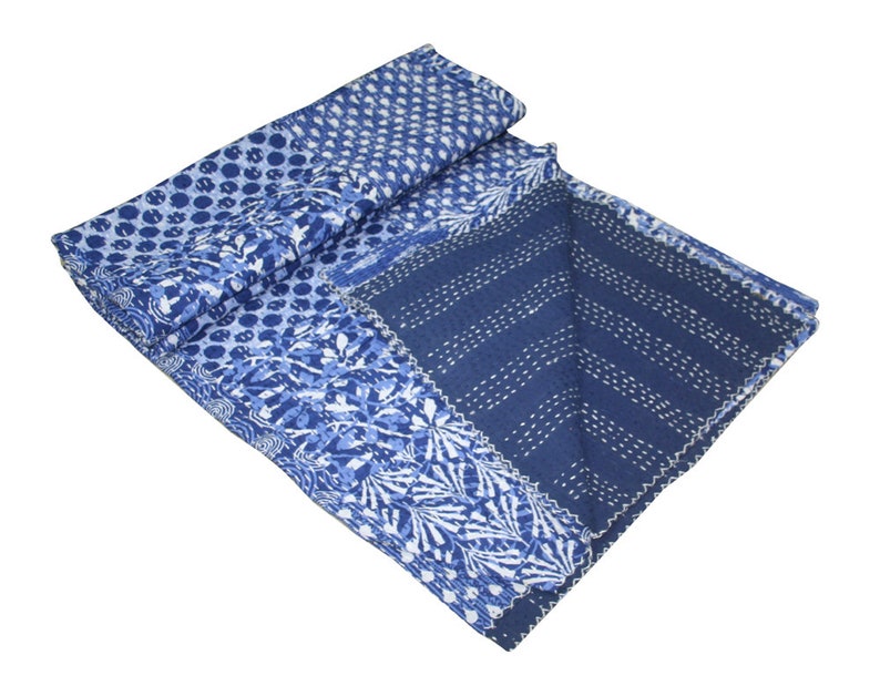 May include: A blue and white kantha quilt with a patchwork design. The quilt is made of cotton and has a hand-stitched pattern.