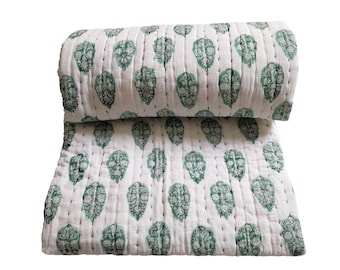 May include: White cotton quilt with a green leaf pattern. The quilt is folded in half and the pattern is visible on both sides.