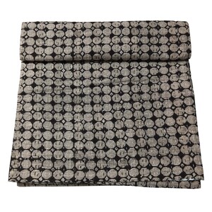 Peut inclure: Une courtepointe kantha noire et blanche avec un motif répétitif de petits cercles. La courtepointe est pliée en deux et est faite de coton.