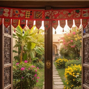 May include: A doorway with intricately carved wooden doors and a vibrant red valance adorned with colorful patterns. The doorway opens to a lush garden with a stone pathway, flowering bushes, and tropical plants. The overall theme is home decor.