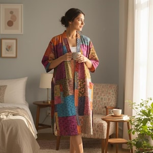 Może przedstawiać: Kolorowy szlafrok w patchworku z mieszanką żywych odcieni, w tym różu, błękitu, pomarańczy i żółci. Szlafrok ma luźny krój i kieszenie. Osoba trzyma kubek w sypialni.