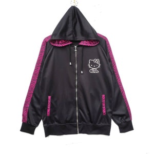 May include: Black zip-up hoodie with pink zebra print on the sleeves and a white Hello Kitty graphic on the front.