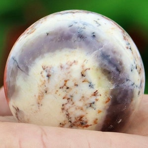 May include: A white, purple, and brown agate sphere with a smooth, polished surface.