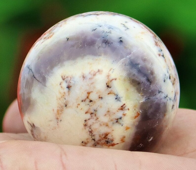 May include: A white, purple, and brown agate sphere with a smooth, polished surface.