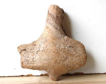 May include: A piece of driftwood with a unique, twisted shape. The wood is light brown and has a rough, weathered texture.