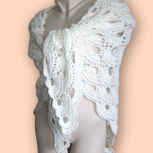Könnte beinhalten: Weißer Häkel-Schal mit einem zarten Lochmuster. Der Schal ist über eine weiße Schaufensterpuppe gelegt.