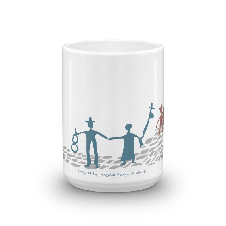 May include: A white ceramic mug featuring a blue graphic of two figures holding hands while walking on a gray cobblestone path. One figure wears a hat and holds a pair of glasses, while the other carries a bag. Text reads Designed by mouzalia Design Studio.