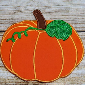 May include: Orange felt pumpkin with a green felt stem and leaf. The leaf has a sparkly green finish.