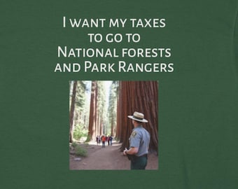 Puede incluir: Una camiseta verde con el texto "Quiero que mis impuestos vayan a los bosques nacionales y a los guardabosques". La camiseta presenta una foto de un guardabosques en un bosque con árboles altos.