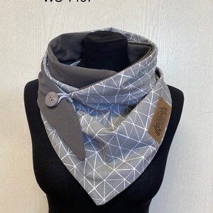 Könnte beinhalten: Grauer und weißer geometrischer Muster-Infinity-Schal mit braunem Knopf und braunem Lederanhänger mit der Aufschrift "Handmade with Love".