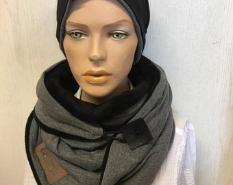 May include: A gray and black reversible infinity scarf with a black beanie. The scarf has a brown leather tag with the word "ORIGINAL" on it.
