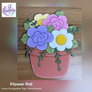 May include: A flat, decorative sign attachment shaped like a terracotta-colored flower pot filled with a bouquet of stylized flowers. The arrangement includes a large purple rose, a white daisy with a yellow center, a pink rose, and green leaves.