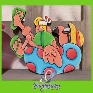 May include: A pink flamingo with a straw hat and sunglasses is relaxing in a blue and red polka dot inflatable ring. The flamingo is holding a glass of orange juice with a straw.
