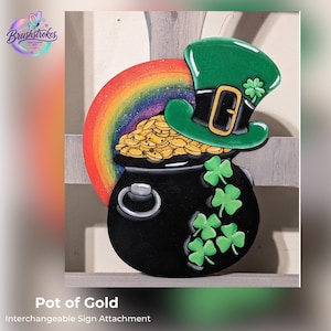 May include: A decorative sign attachment featuring a black pot filled with gold coins, topped with a green leprechaun hat with a gold buckle and a shamrock. A colorful rainbow arches behind the pot, and green shamrocks decorate the side.