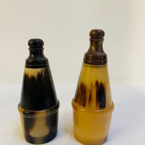 Puede incluir: Un juego de tres tazas de cerámica con un acabado moteado y mate. Las tazas son de color crema, gris claro y gris oscuro. Cada taza tiene un diseño simple y minimalista.