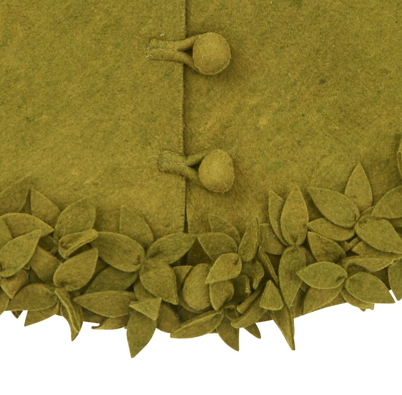 May include: A green felt skirt with a leaf trim. The skirt has two buttons on the front.
