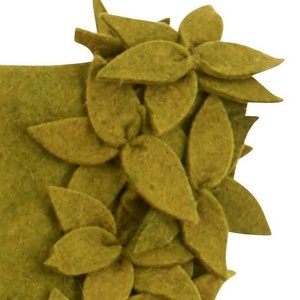 May include: A green felt wreath with a decorative design of overlapping leaves and flowers.