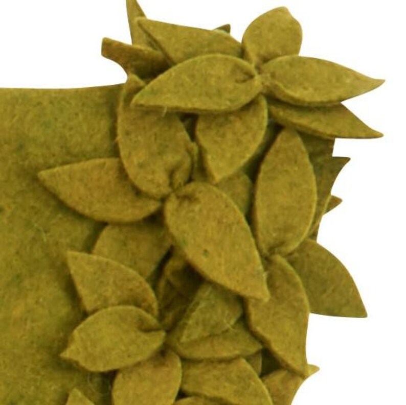 May include: A green felt wreath with a decorative design of overlapping leaves and flowers.