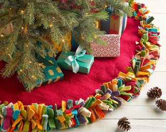 May include: A red felt Christmas tree skirt with a colorful, fringed trim. The skirt is decorated with wrapped presents, including a teal box with a blue ribbon.