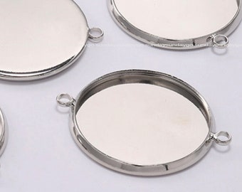 May include: Several silver-coloured, round pendant trays with small loops for attaching chains or other components. Some trays are open, while others are solid. These are ideal for jewellery making.